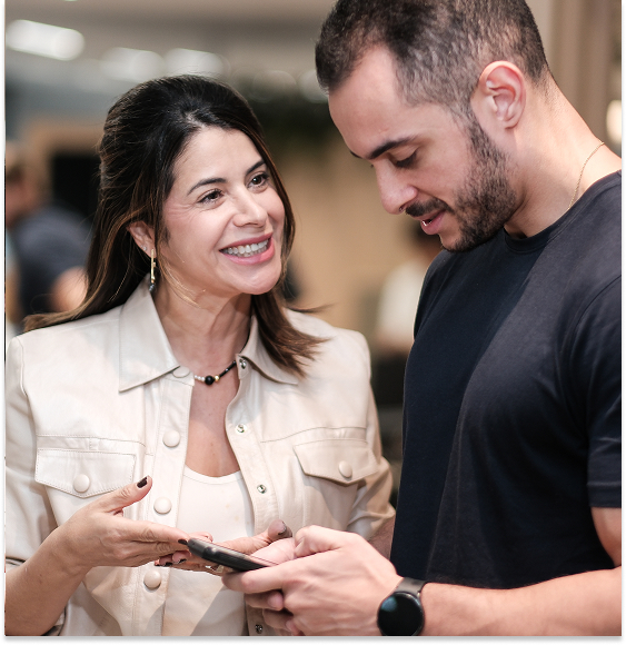 homem olhando para o celular, ao lado de colega que o observa